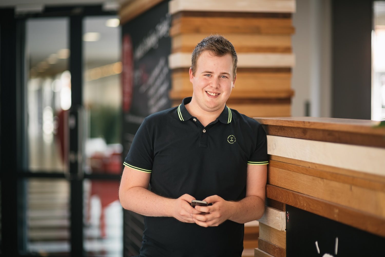 A man smiling whilst on his phone