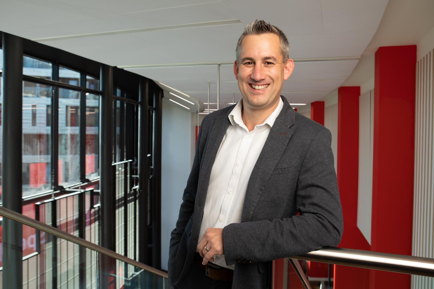 A man smiling on a staircase inside our Speechmark office location