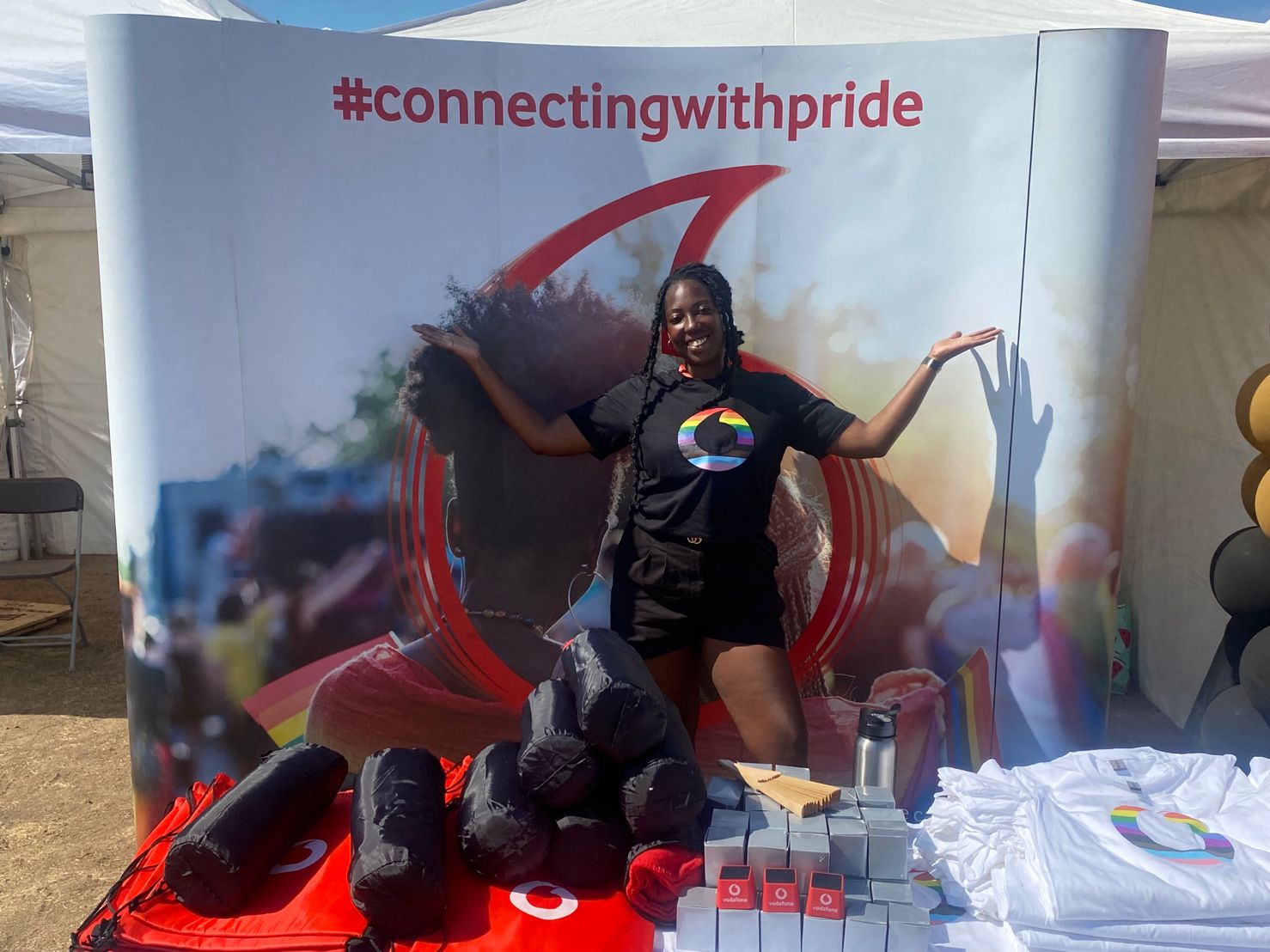 A woman stood in front of the connecting with pride banner at UK Black Pride event