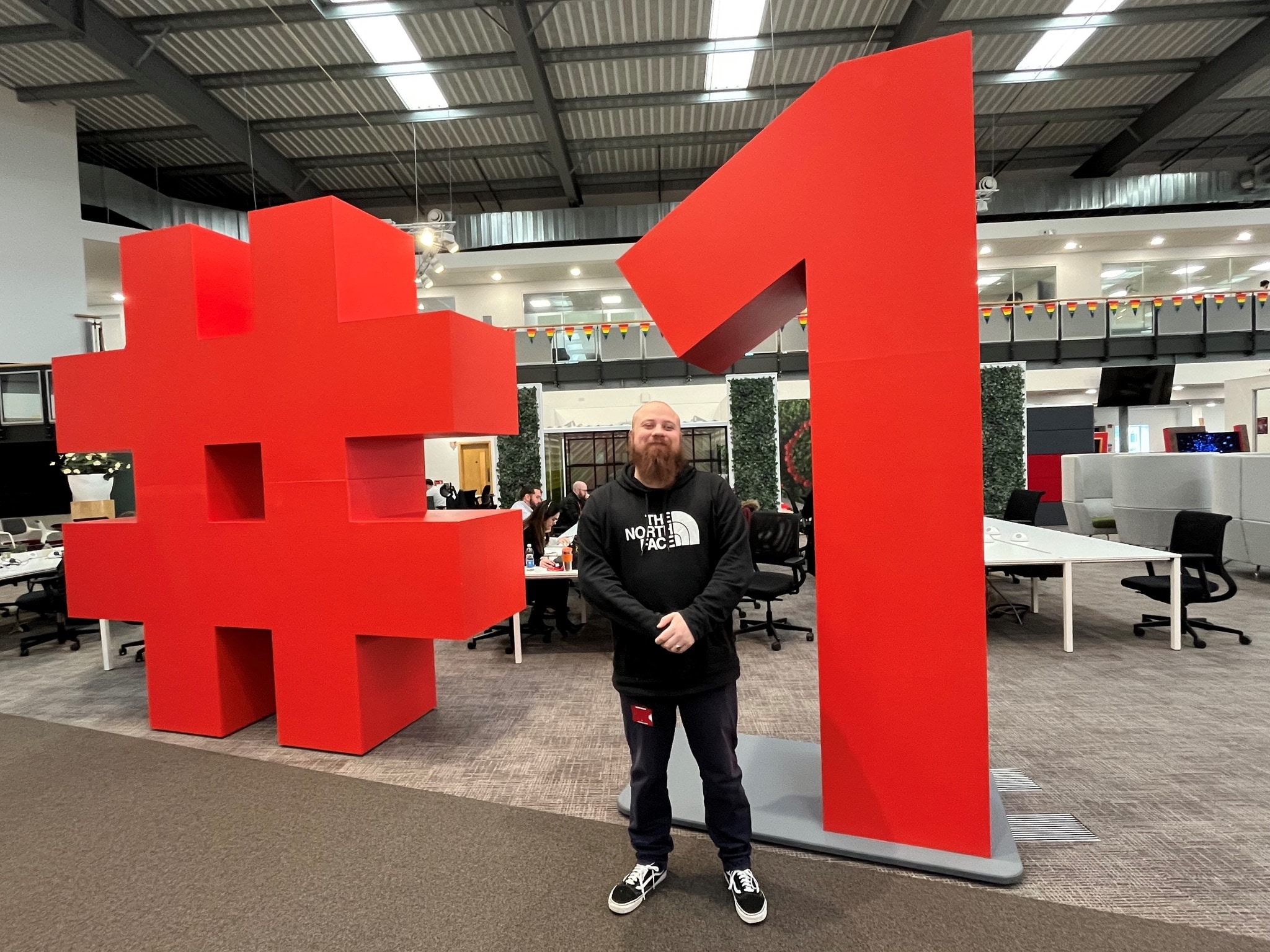 A person standing in front of a large hashtag number 1 physical stand