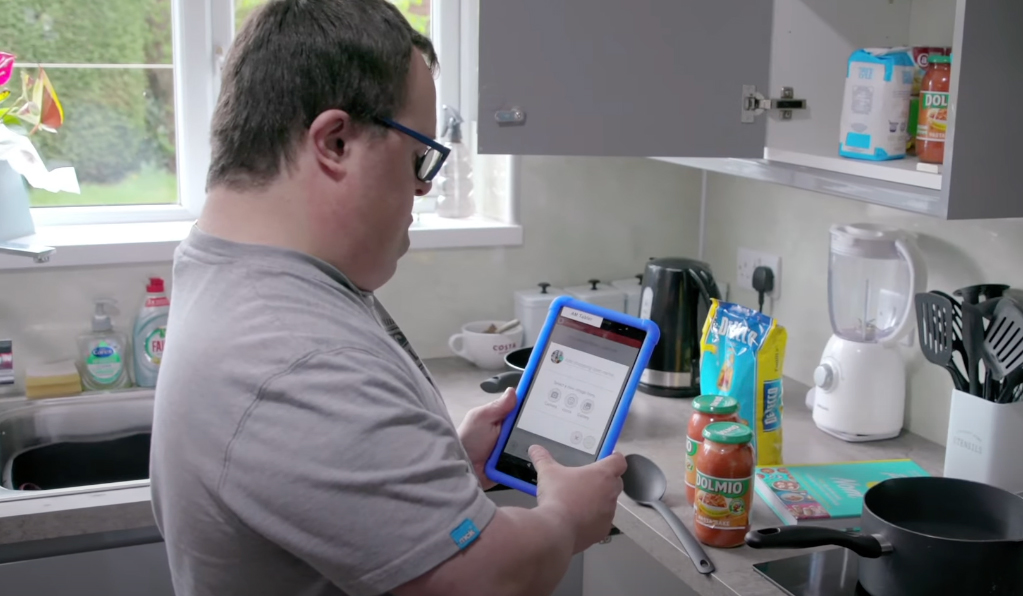 A man on an ipad in his kitchen