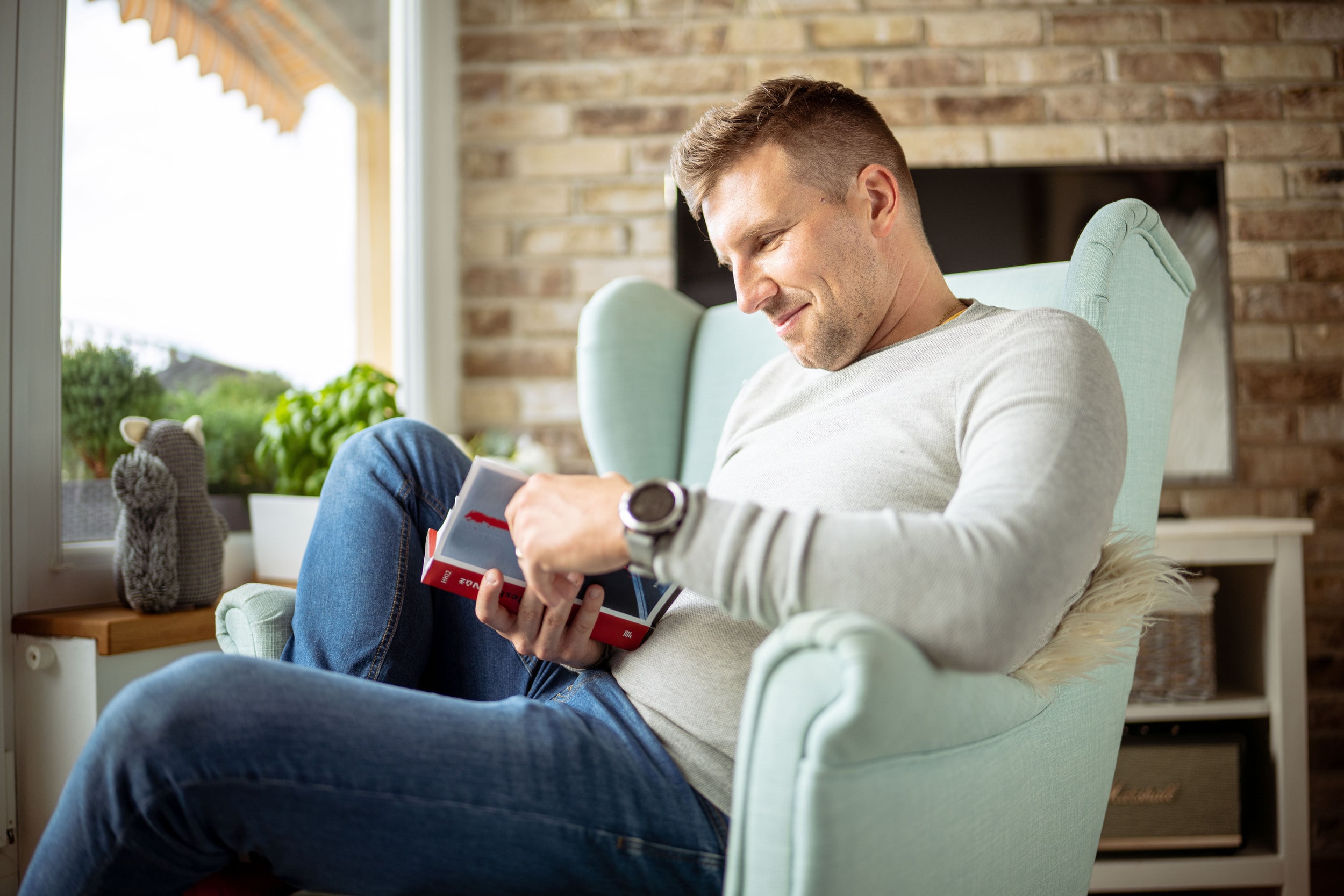 A man reading a book on a chair