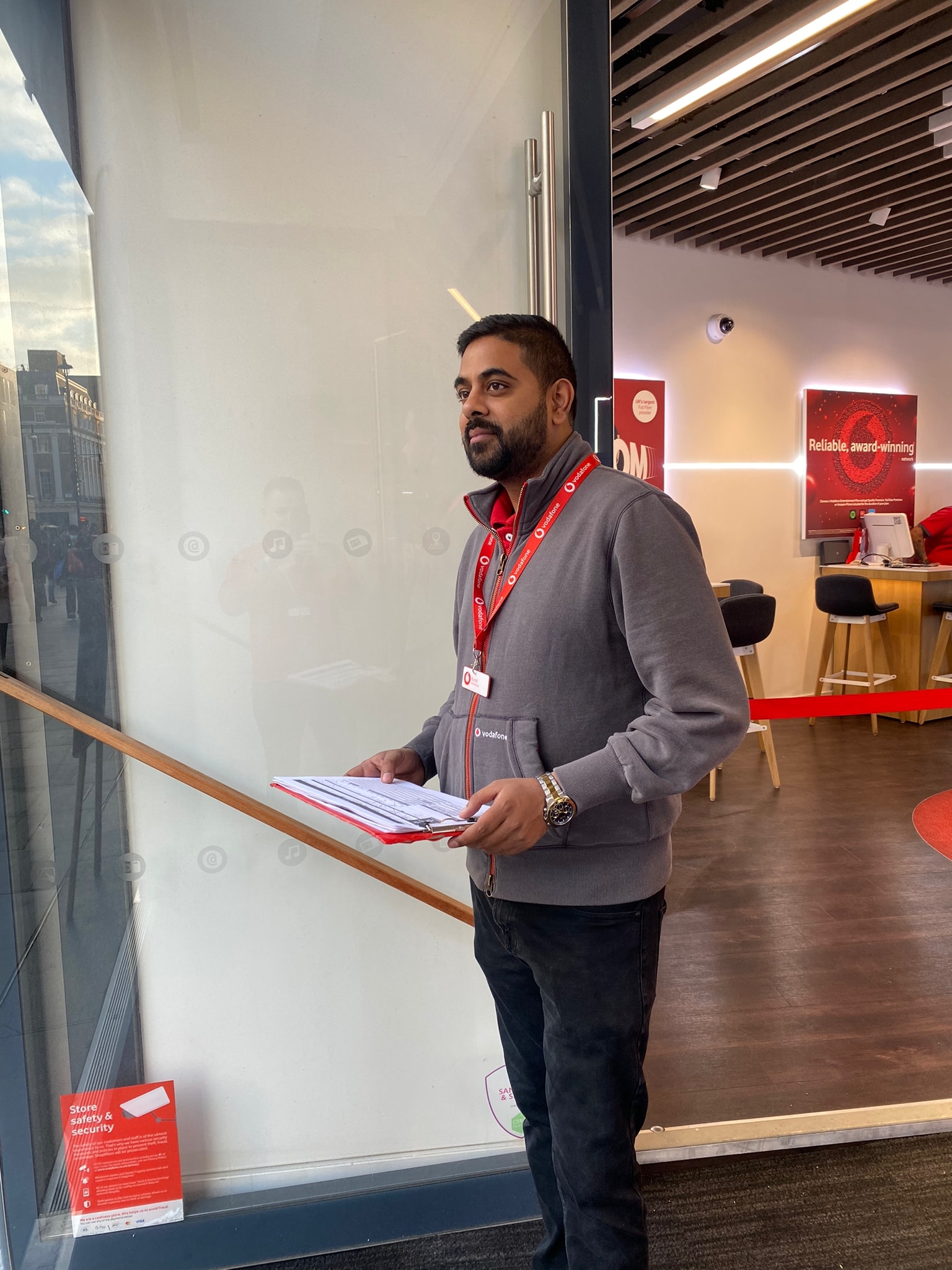 A Vodafone retail colleague in the retail store speaking to a customer