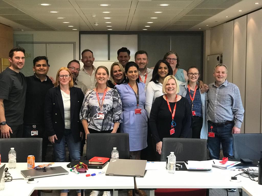 A group of people smiling in a team meeting in the office
