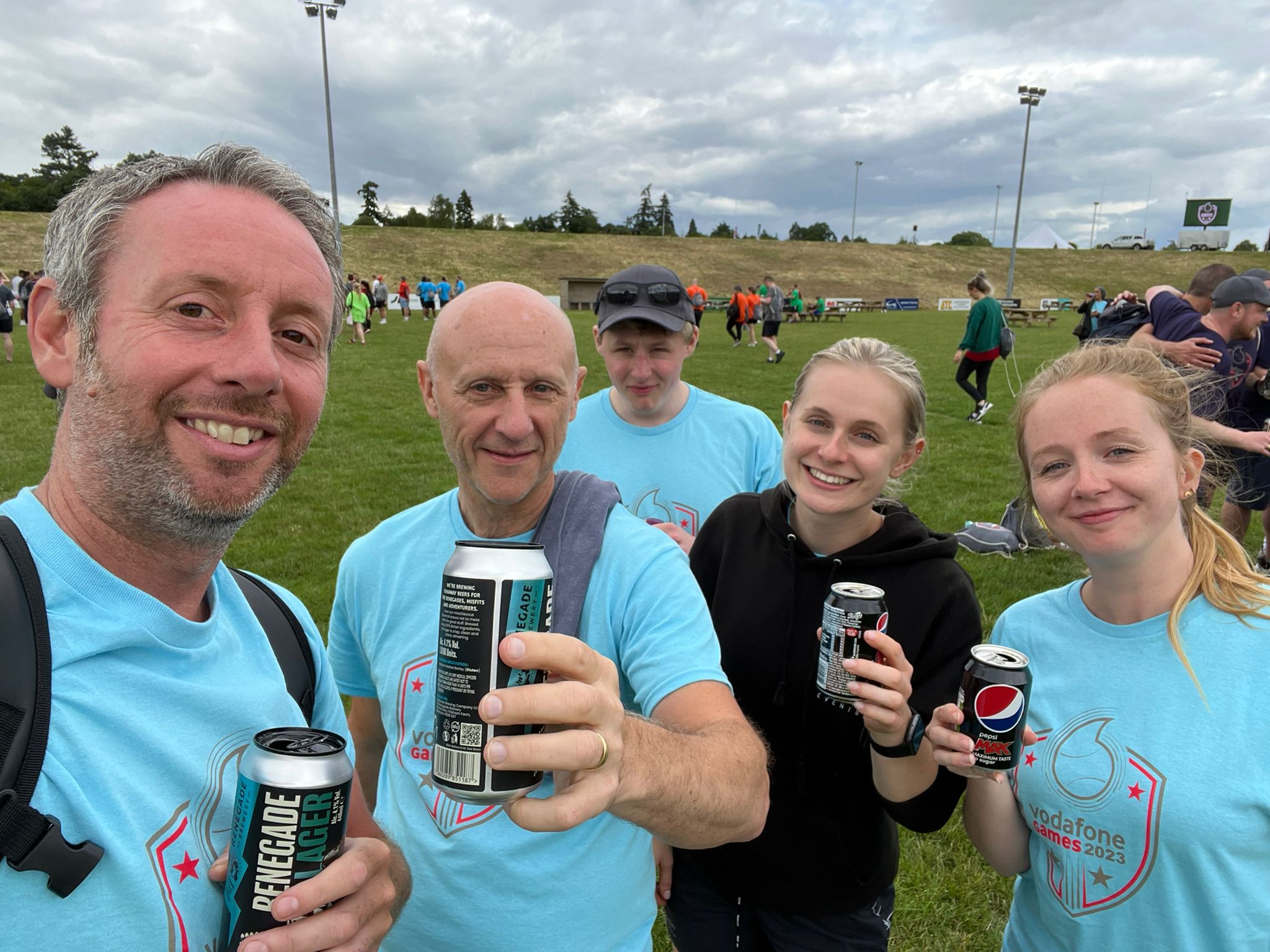 A team celebrating with a drink at an internal event, outside