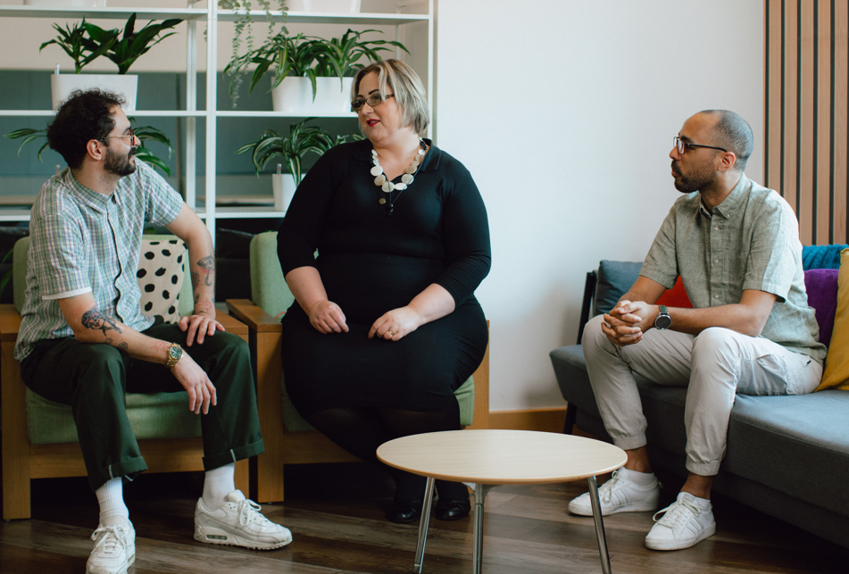 Three people talking to each other inside a Vodafone office